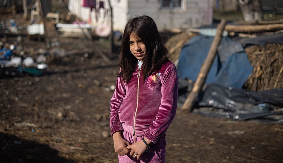 Adina aus Rumänien steht vor ihrer 1-Zimmer Hütte