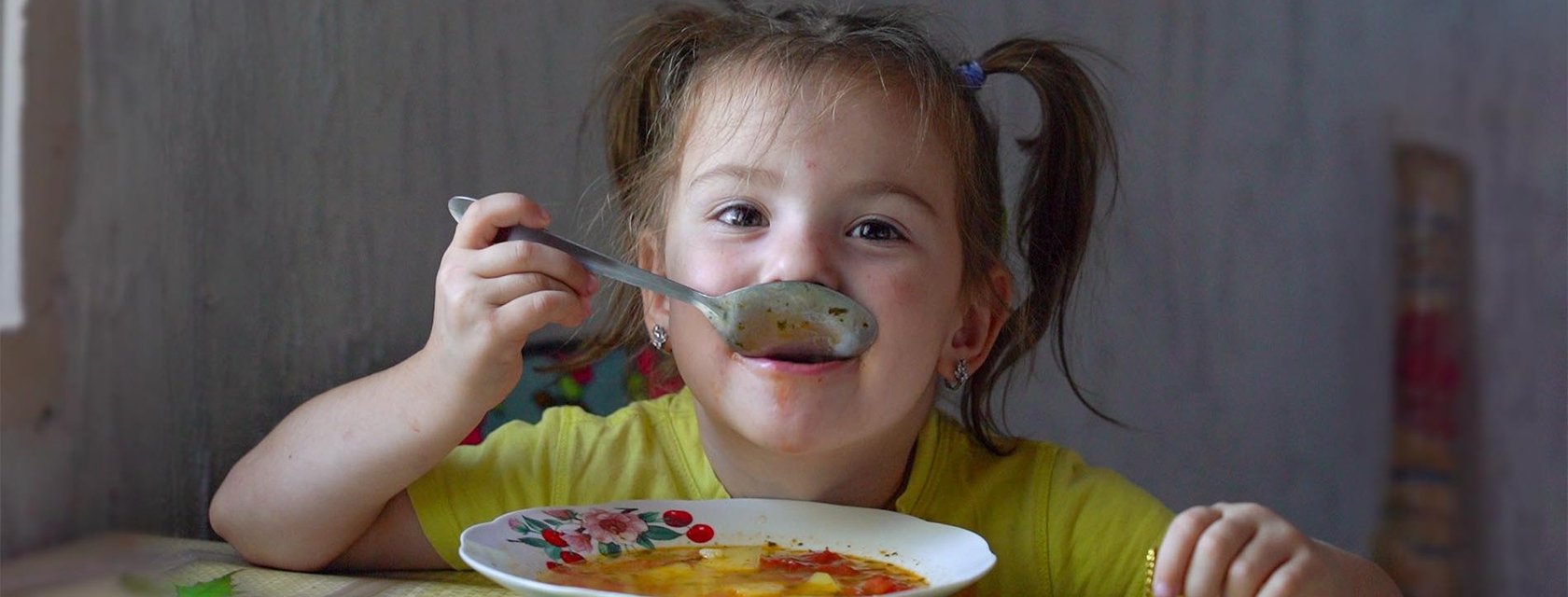 Mädchen in Moldau isst Suppe